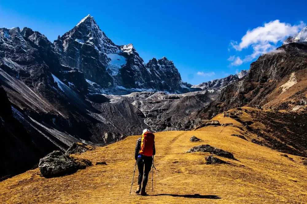 a person walking towards the mountain