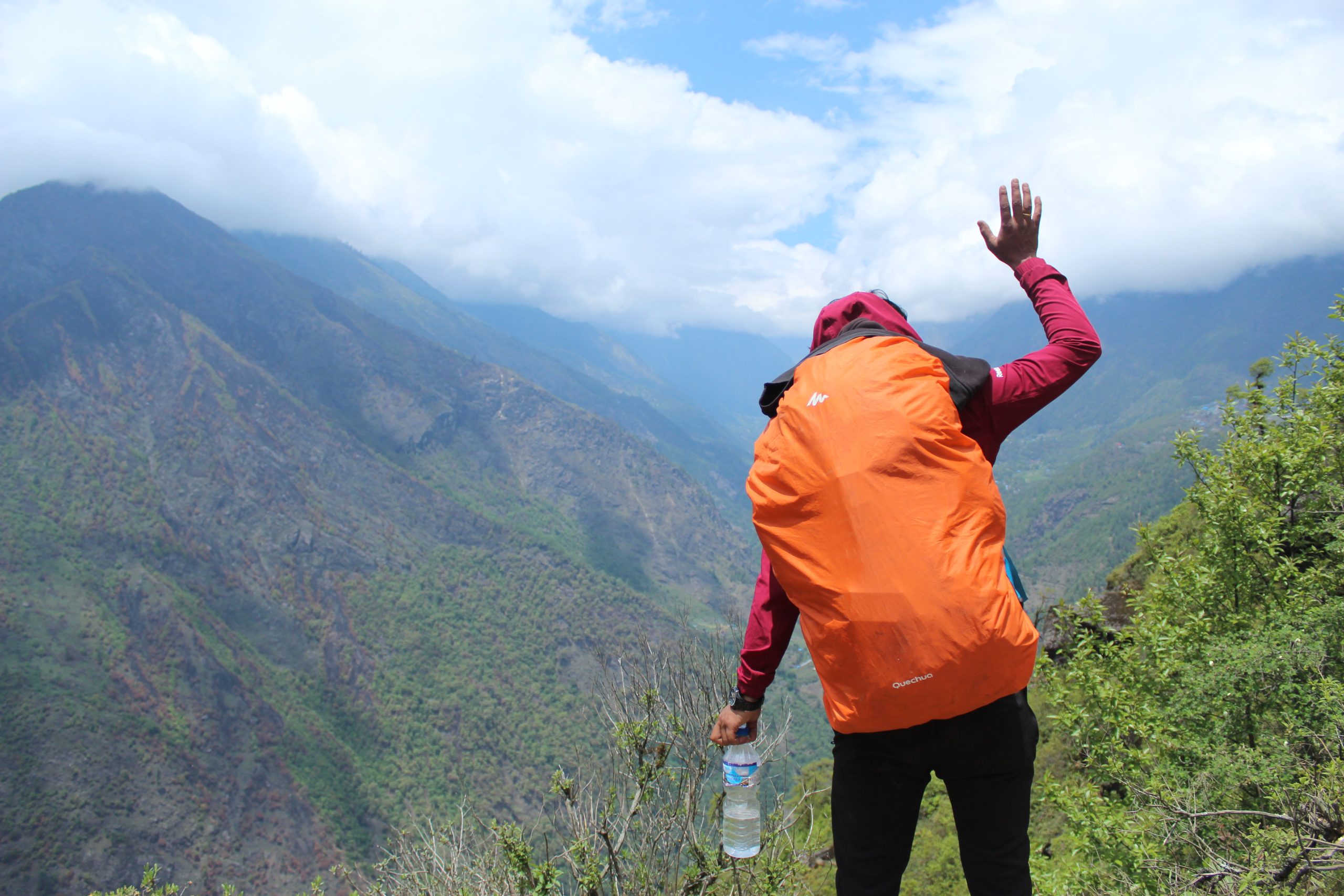 a person waving hand towards the cloudy mountains on the way to namche